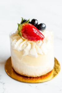 Mini cheesecake topped with frosting, strawberry and blueberries as made famous by Sweets by Diane in Roseville, Minnesota.