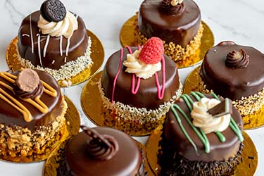 Learn about the best chocolate cakes with different fruit, frosting, and cookie toppings in Roseville Minnesota for lunch is served at Sweet & Savory By Diane at the POTLUCK Food Hall in Rosedale Center.