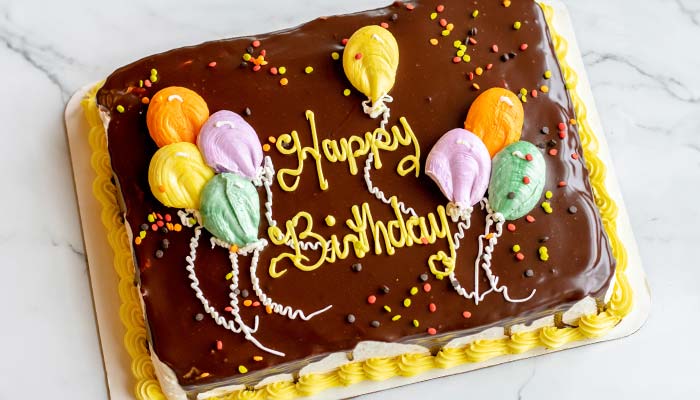 Custom happy birthday balloon decorated chocolate cake baked by Sweet & Savory By Diane in Roseville, MN at the POTLUCK Food Hall in Rosedale Center.